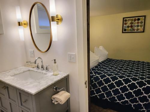 a bathroom with a sink and a mirror and a bed at Bluebird Guesthouse in Portland
