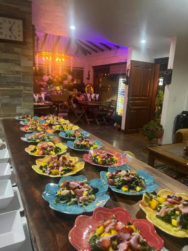 a long table with plates of food on it at Casa De Las Flores Hotel SPA in Villa de Leyva