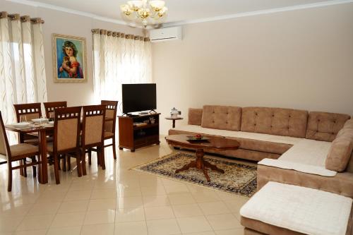 ein Wohnzimmer mit einem Sofa und einem Tisch in der Unterkunft New Bazaar Bliss in Tirana