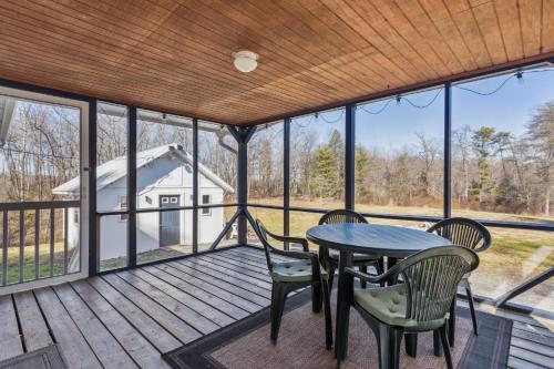 a large screened porch with a table and chairs on it at Valley Vista-Mins to SkylineDrive-Hot Tub-King, Queen Beds in Front Royal