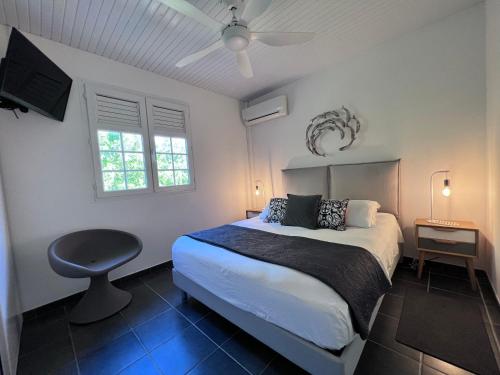 a bedroom with a bed and a ceiling fan at BEACHFRONT Diamond Rock - Guest Suite with breakfast area OR Entire Apartment in Le Diamant
