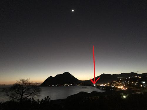 a red object in the sky over a body of water at Face à la Plage avec Parking Sécurisé Appartement de Luxe ou Suite Privée avec Coin Petit Déj selon Disponibilité in Le Diamant