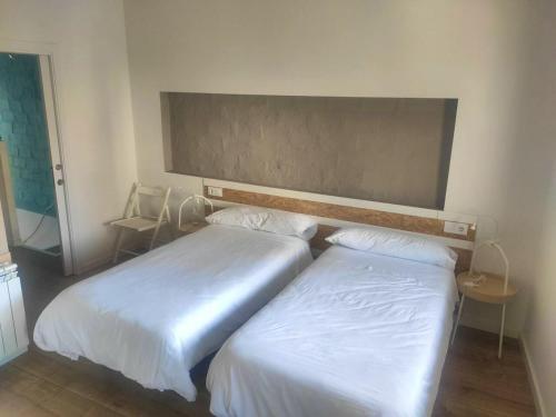 2 Betten in einem Hotelzimmer mit weißer Bettwäsche in der Unterkunft 2 bedrooms appartement with terrace and wifi at Xativa in Xàtiva