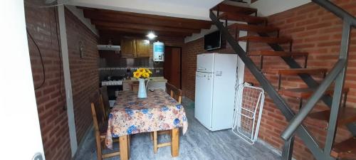 a small kitchen with a table and a refrigerator at El Rincón de José in Villa Cura Brochero