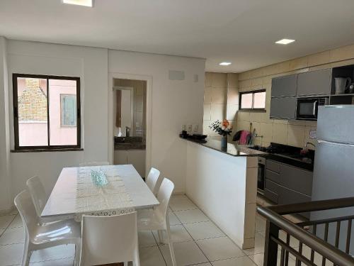 a kitchen with a table and chairs in a kitchen at Apto. Beverlly Hills, Próx. Beach Park in Aquiraz