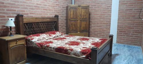 a bedroom with a bed and a brick wall at El Rincón de José in Villa Cura Brochero