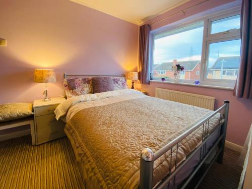 sypialnia z dużym łóżkiem i oknem w obiekcie Purple dream double bedroom w mieście Cheltenham