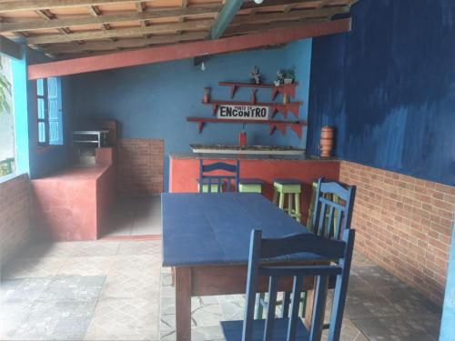 een eetkamer met een blauwe tafel en stoelen bij Hostel Descanso dos Amigos Reserve Quarto Completo in Prado