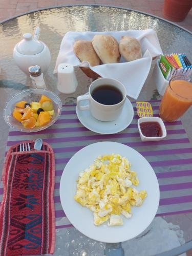 a table with plates of food and a cup of coffee at Posada Nueva España in Arequipa