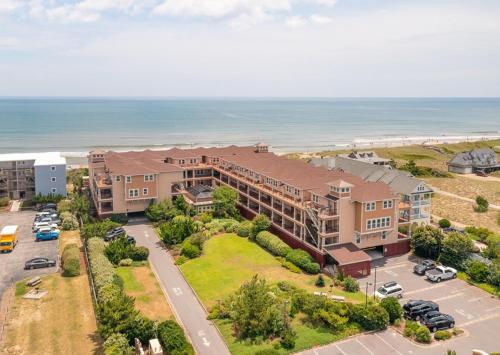an aerial view of a building with a parking lot and the ocean at Salty Shenanigans in Kill Devil Hills