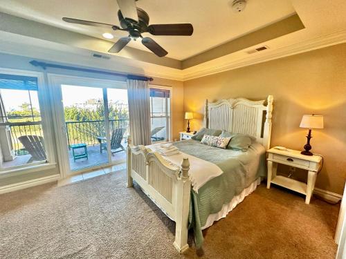 a bedroom with a bed and a ceiling fan at Salty Shenanigans in Kill Devil Hills