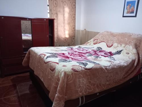 a bedroom with a bed with pink flowers on it at Apartamento Centro histórico in Bogotá