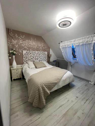 a bedroom with a bed and a blue curtain at Élégante maison circuit des 24h00 du mans in Le Mans