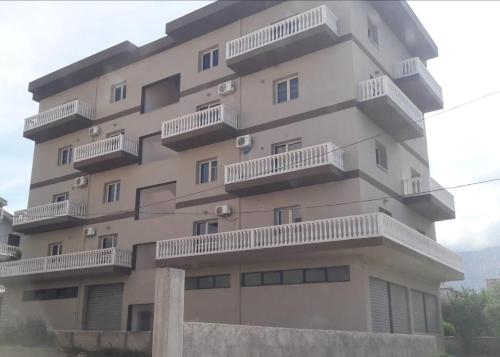 a tall building with balconies on the side of it at George’s Apartment in Orikum