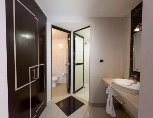 a bathroom with a shower and a sink and a toilet at Hotel Maria Dolores Rio Verde in Río Verde