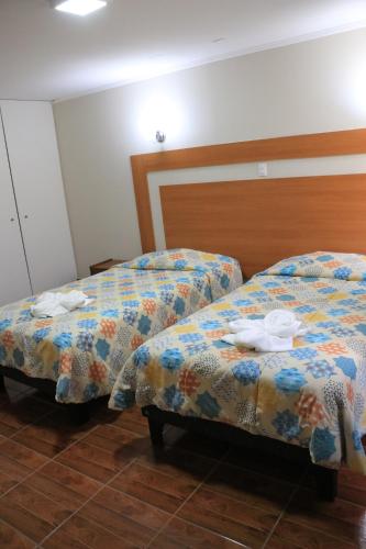two beds sitting next to each other in a room at Hotel Garden Latorre in Iquique