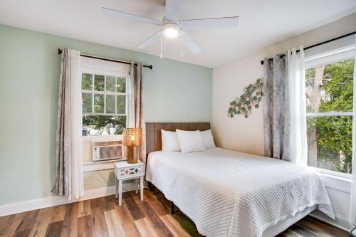 a bedroom with a bed and two windows at Downtown Navy Blue in Pensacola