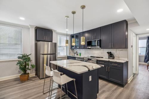 a kitchen with black cabinets and a stainless steel refrigerator at AF Stays - Philadelphia Callowhill in Philadelphia