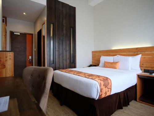 a hotel room with a large bed and a desk at Cuarto Hotels Cebu in Cebu City