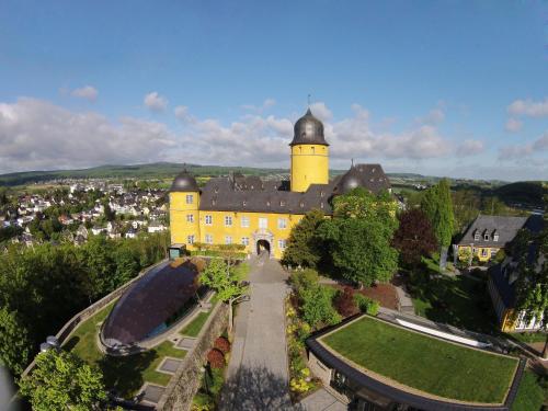 an aerial view of a yellow building with a tower at Hotel Schloss Montabaur in Montabaur
