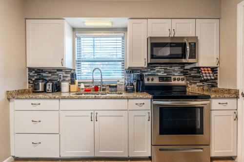 a kitchen with white cabinets and a stove top oven at ZenHomes in Tampa near USF in Tampa