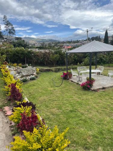 a garden with a gazebo and a picnic table at La Chelita in Quito