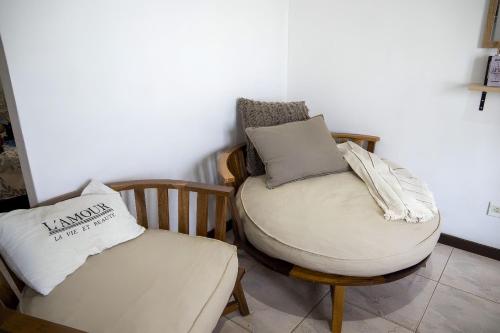 Habitación con silla y reposapiés con almohadas. en Refugio de plata, La Florida en Munro