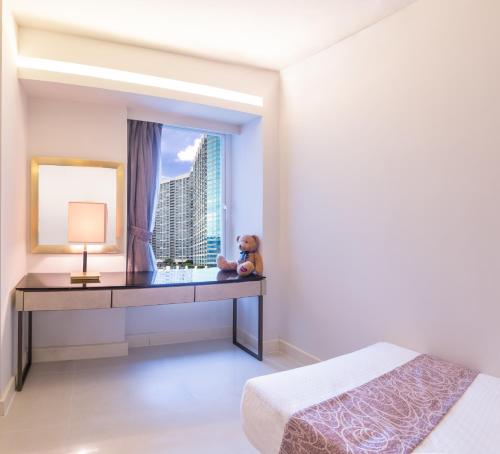 a bedroom with a desk with a teddy bear on it at Kowloon Harbourfront Hotel in Hong Kong