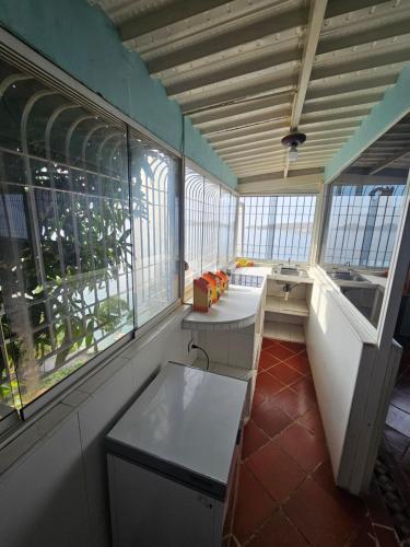 a room with windows and a kitchen with a sink at Mochima Inn 