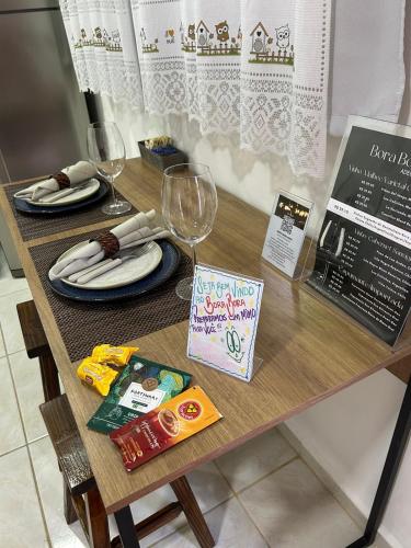 a wooden table with wine glasses and food on it at BORA BORA RESIDENCE in Joinville