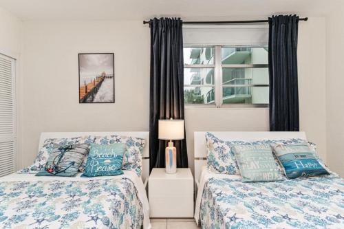 1 dormitorio con 2 camas y ventana en Beachfront Modern 5 Stars 1 Bedroom Apartment, en Hollywood