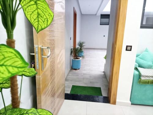 a hallway with a door leading to a room with plants at Appartement de luxe in Kenitra