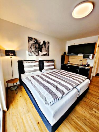 1 dormitorio con 1 cama grande en una habitación en Lions Place Premium Apartments BUSINESS optionaler Zugang zum SPA- Bereich, en Heidenheim an der Brenz