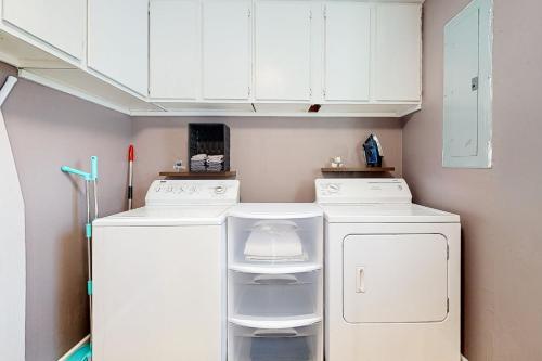 a kitchen with white cabinets and a washer and dryer at Getaway on Gossett in Spartanburg