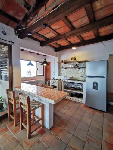 a kitchen with a large table and a refrigerator at Casa Rey Sol Vallarta in Puerto Vallarta