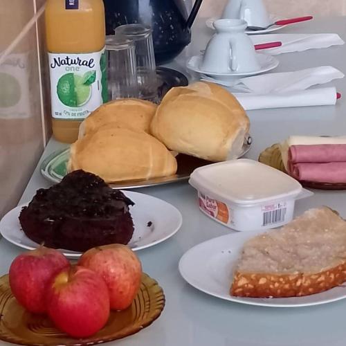 een tafel met borden brood, appels en zoete deegwaren bij Pousada Rainha do Mar in Beberibe