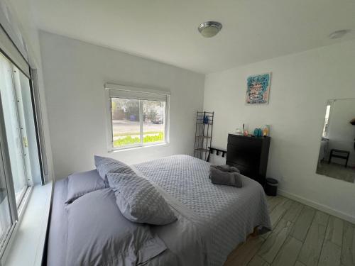 Habitación blanca con cama y ventana en Cozy room in a quiet home, en Miami