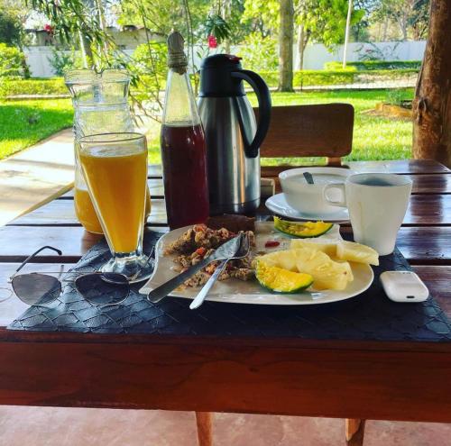 un tavolo con un piatto di cibo e una bevanda di Calamari Beach Resort a Zanzibar City