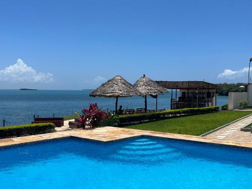 a swimming pool with a view of the ocean at Calamari Beach Resort in Zanzibar City