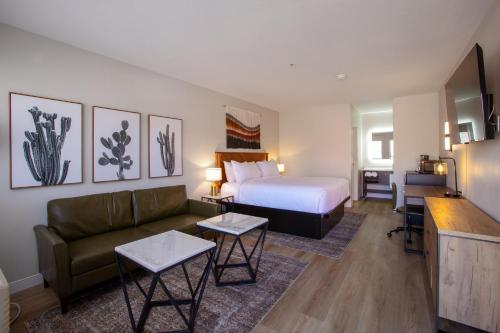 um quarto de hotel com uma cama e um sofá em Kokopelli Inn Sedona, Trademark Collection by Wyndham em Sedona