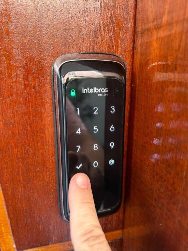 a hand is pressing a remote control on a door at BORA BORA RESIDENCE in Joinville