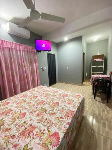 1 dormitorio con 1 cama grande con colcha rosa en Ñande Roga, en Asunción