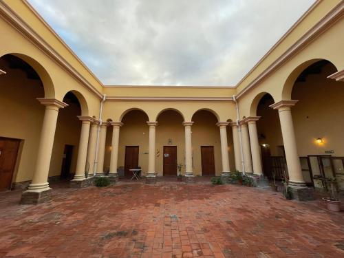 an empty building with a large room with pillars at Colegio de María in Cafayate