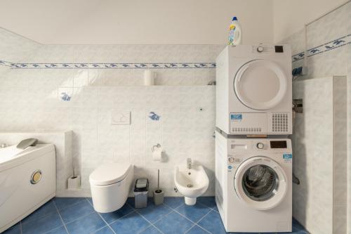 uma casa de banho com uma máquina de lavar roupa e um WC em AD Apartment Tonndorf em Hamburgo