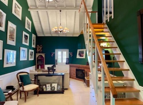 a living room with a staircase and green walls at Herdade de Santa Maria in Almeirim