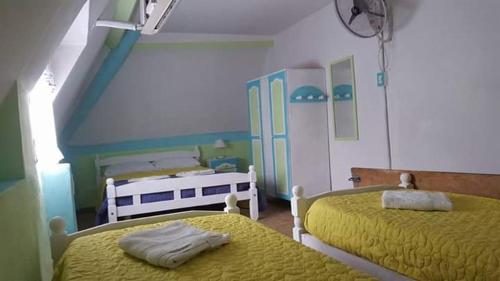 a room with three beds with yellow sheets and blue walls at Cabañas Fénix in La Guardia