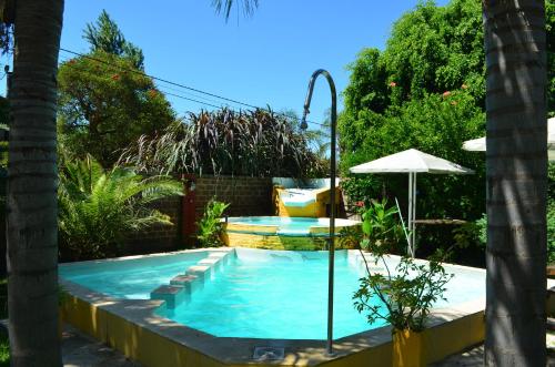 a swimming pool with an umbrella in a yard at Cabañas Fénix in La Guardia