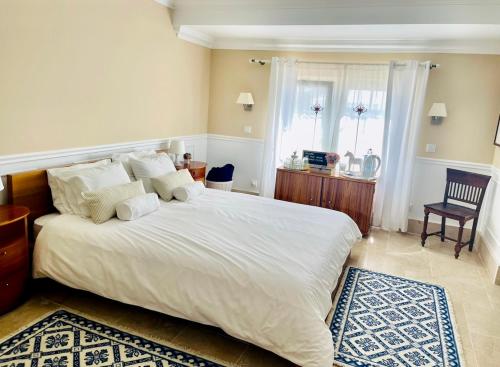 ein Schlafzimmer mit einem großen weißen Bett und einem Fenster in der Unterkunft Herdade de Santa Maria in Almeirim