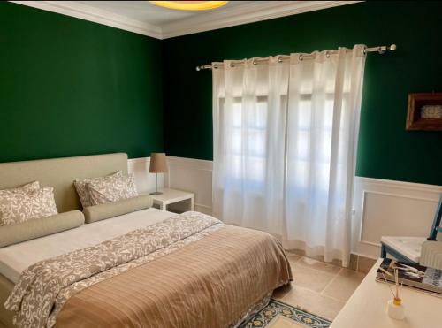 a bedroom with a bed and a green wall at Herdade de Santa Maria in Almeirim