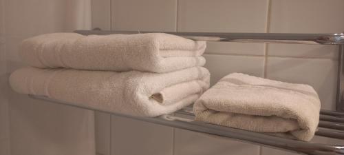 a group of towels on a shelf in a bathroom at Apart Hotel Inga Providencia in Santiago